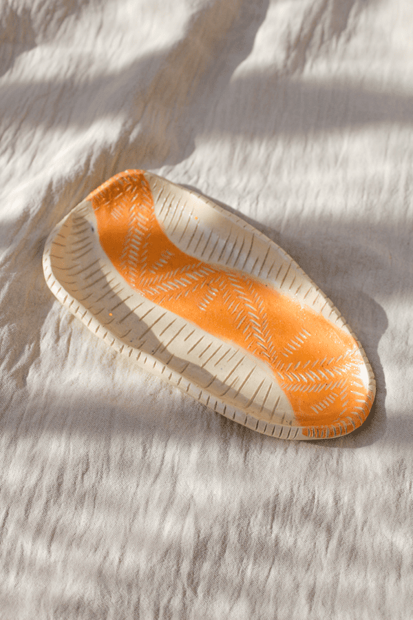 fotografía de producto de un plato de cerámica artesanal alargado naranja